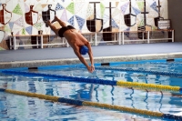 Detalle de la piscina con nadador al frente y su caracterstico fondo de azulejos al fondo.