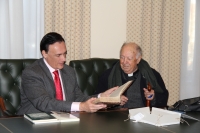 El rector, José Carlos Gómez Villamandos, recibe de manos de Álvaro Huerga, el volumen más antiguo de la donación.